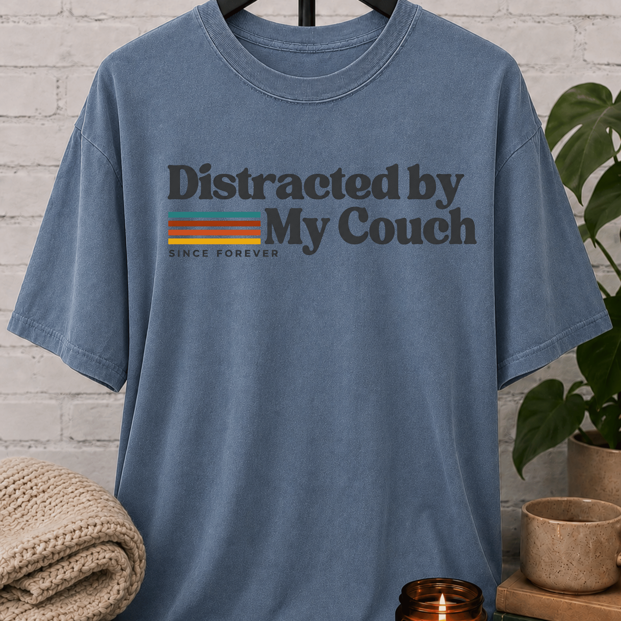 Funny homebody T-shirt featuring “Distracted by My Couch Since Forever” with retro stripes, a couch potato graphic tee for stay-home lovers and indoorsy people.