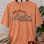 Western homebody T-shirt featuring rope-style lettering and the phrase “People Are a Lot Darlin’ That’s Why I Stay Home,” a funny sarcastic graphic tee for introverts, antisocial personalities, and stay-home lovers.