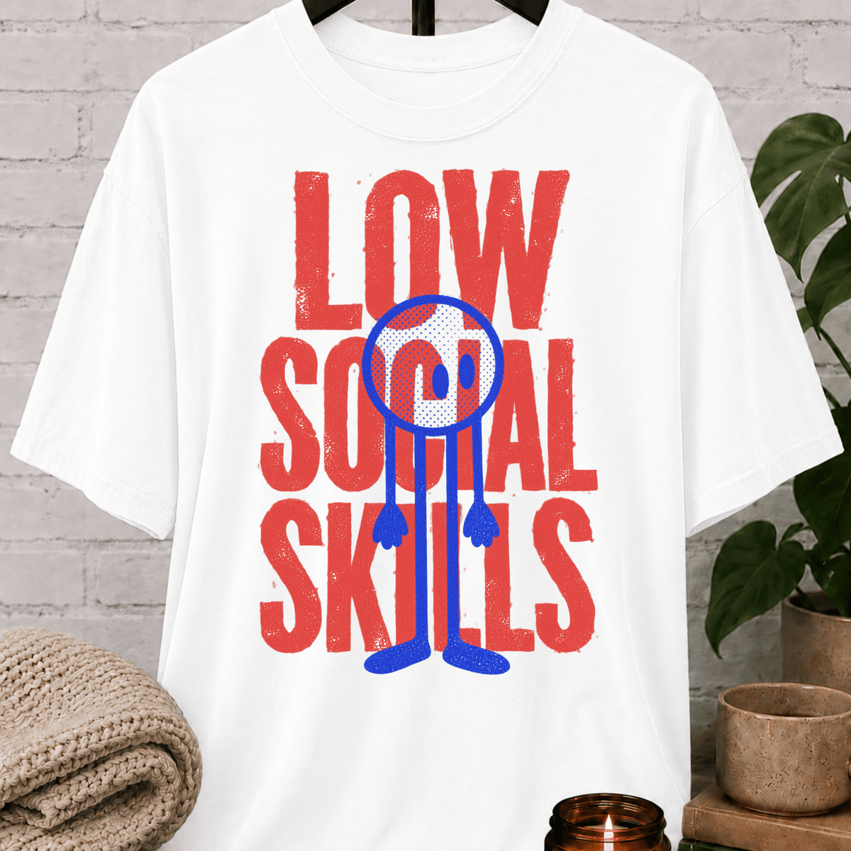 Low Social Skills graphic T-shirt featuring a distressed deadpan face design, a funny socially awkward shirt for awkward humor fans and people who avoid unnecessary socializing.