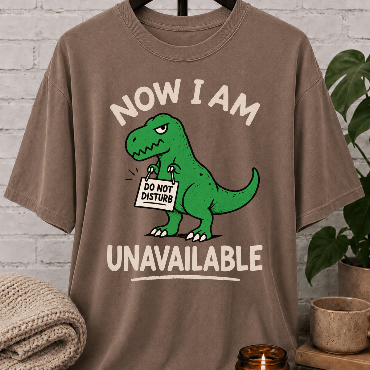 Funny dinosaur T-shirt featuring a green T-rex holding a “Do Not Disturb” sign with the phrase “Now I Am Unavailable,” a sarcastic loner graphic tee for hermits, socially unavailable types, and personal space humor fans.