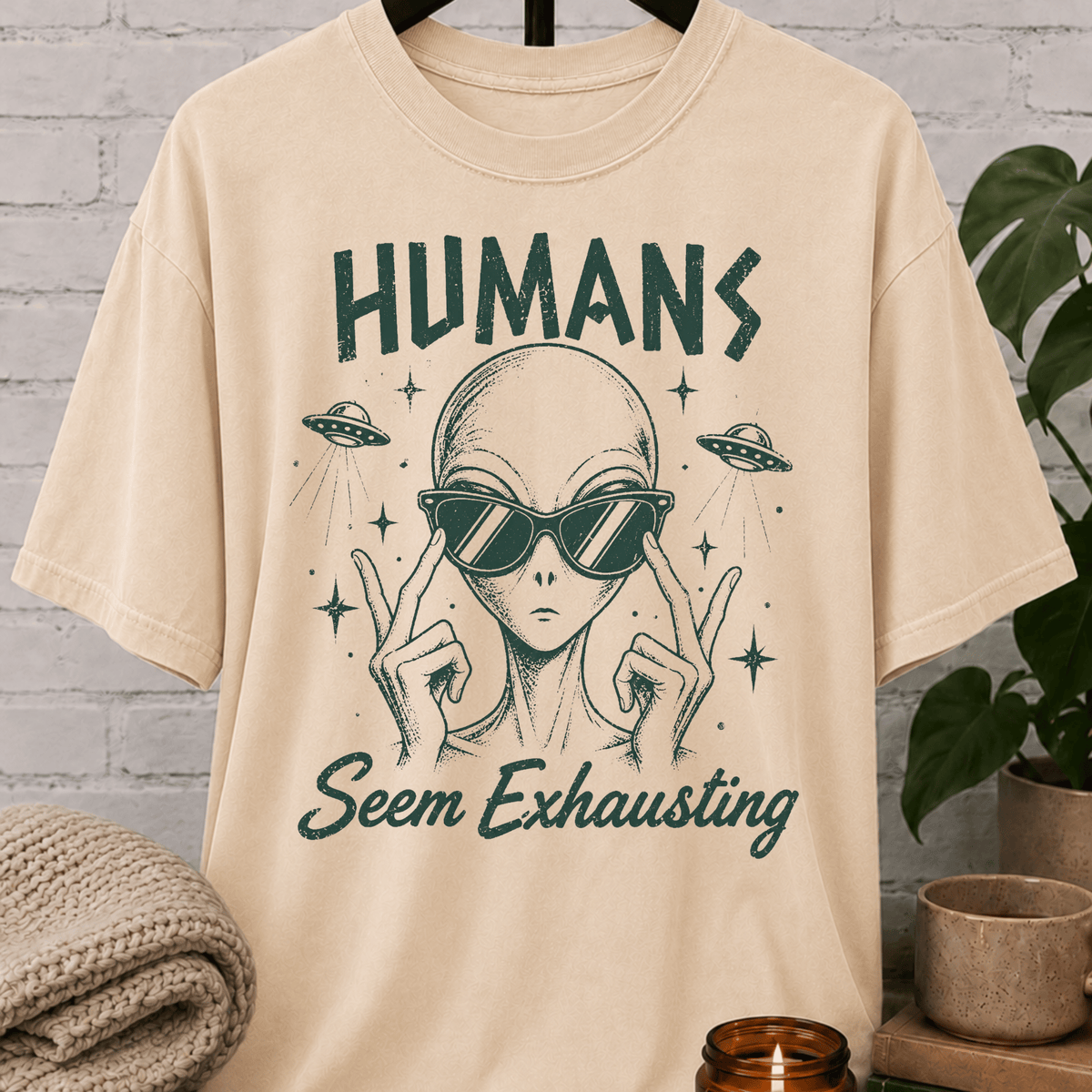 Funny alien graphic T-shirt featuring a sunglasses-wearing extraterrestrial with UFOs and the phrase “Humans Seem Exhausting,” a sarcastic introvert shirt for socially drained people, antisocial humor fans, and lovers of quirky space designs.
