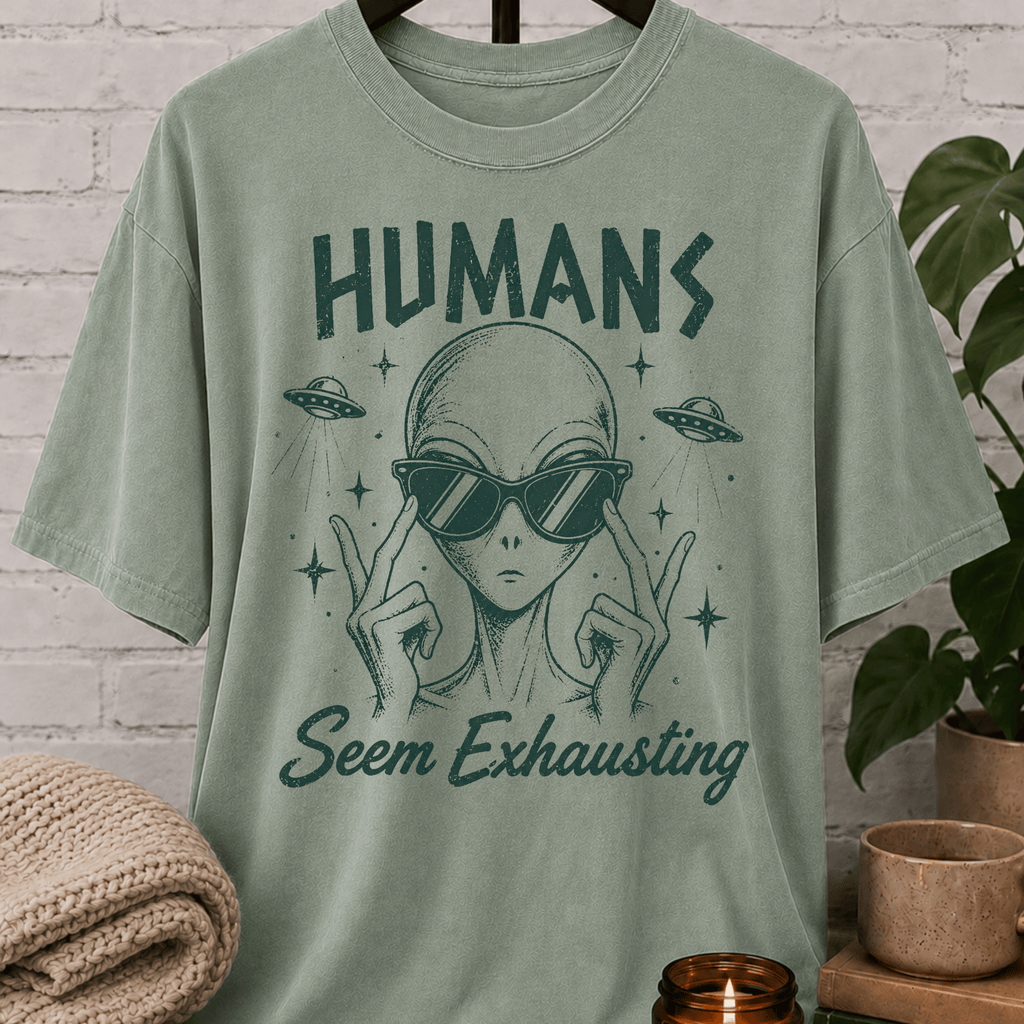 Funny alien graphic T-shirt featuring a sunglasses-wearing extraterrestrial with UFOs and the phrase “Humans Seem Exhausting,” a sarcastic introvert shirt for socially drained people, antisocial humor fans, and lovers of quirky space designs.