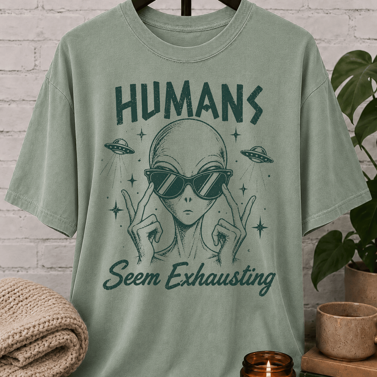 Funny alien graphic T-shirt featuring a sunglasses-wearing extraterrestrial with UFOs and the phrase “Humans Seem Exhausting,” a sarcastic introvert shirt for socially drained people, antisocial humor fans, and lovers of quirky space designs.