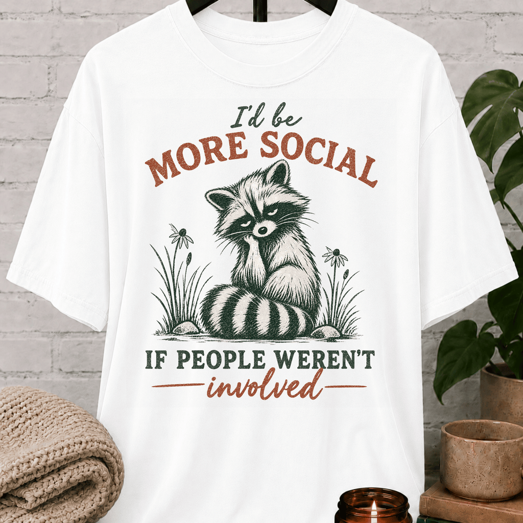 Funny raccoon graphic T-shirt featuring a vintage raccoon and the phrase “I’d Be More Social If People Weren’t Involved,” a sarcastic antisocial shirt for socially selective people and fans of avoid-people humor.
