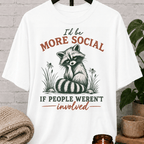 Funny raccoon graphic T-shirt featuring a vintage raccoon and the phrase “I’d Be More Social If People Weren’t Involved,” a sarcastic antisocial shirt for socially selective people and fans of avoid-people humor.