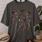 Fall Halloween skeleton T-shirt featuring three dancing skeletons, autumn leaves, bats, and a jack-o’-lantern, a spooky graphic tee for introverts and Halloween lovers.