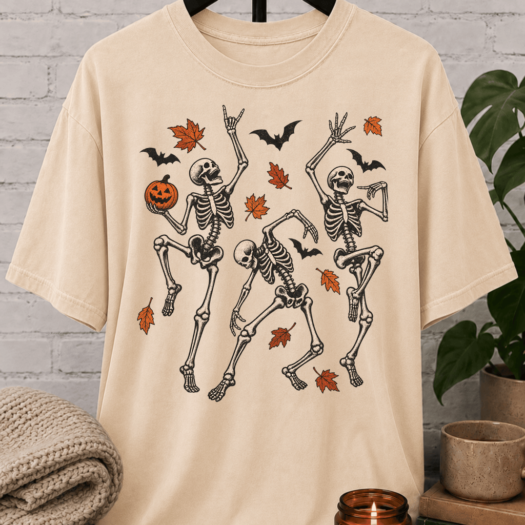 Fall Halloween skeleton T-shirt featuring three dancing skeletons, autumn leaves, bats, and a jack-o’-lantern, a spooky graphic tee for introverts and Halloween lovers.