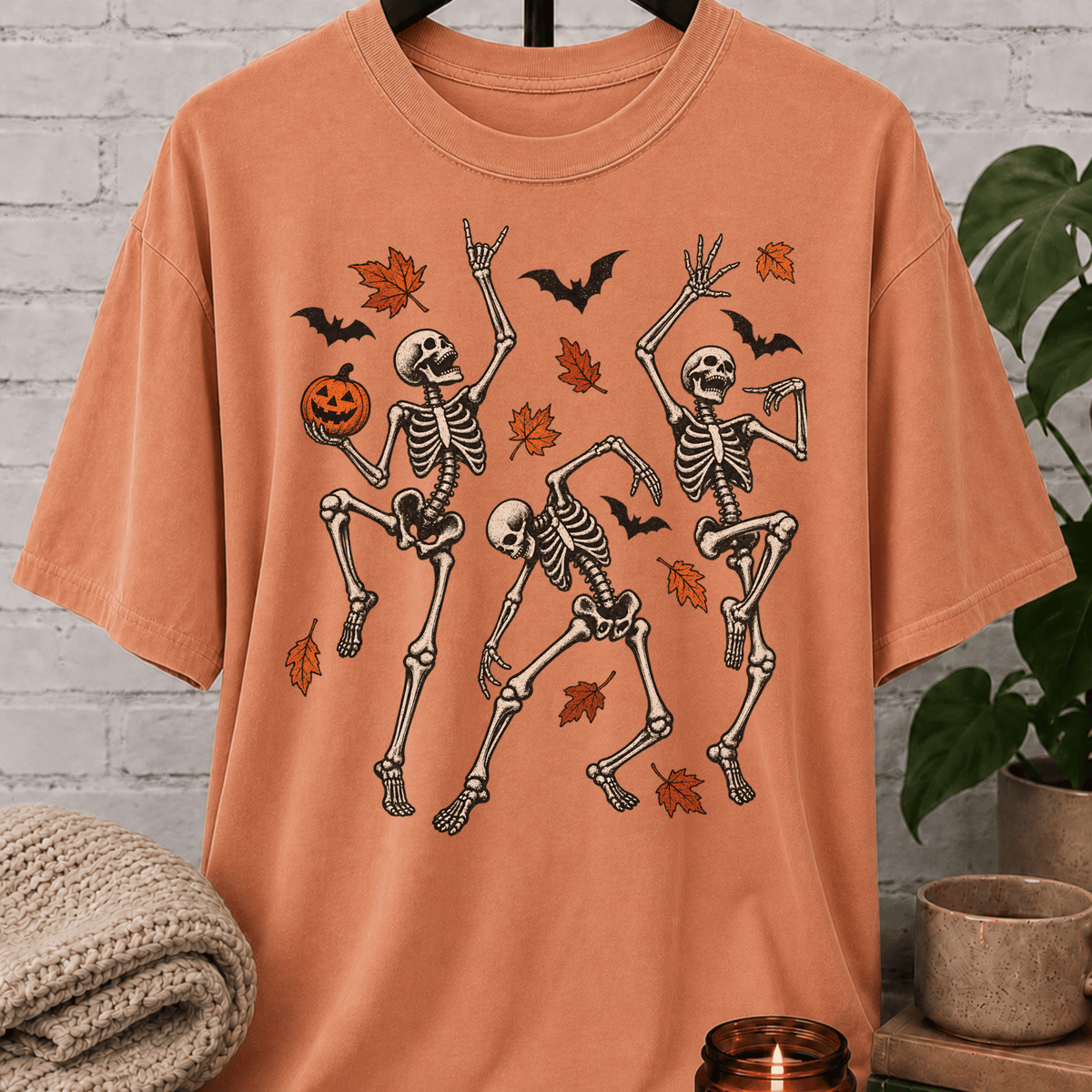 Fall Halloween skeleton T-shirt featuring three dancing skeletons, autumn leaves, bats, and a jack-o’-lantern, a spooky graphic tee for introverts and Halloween lovers.