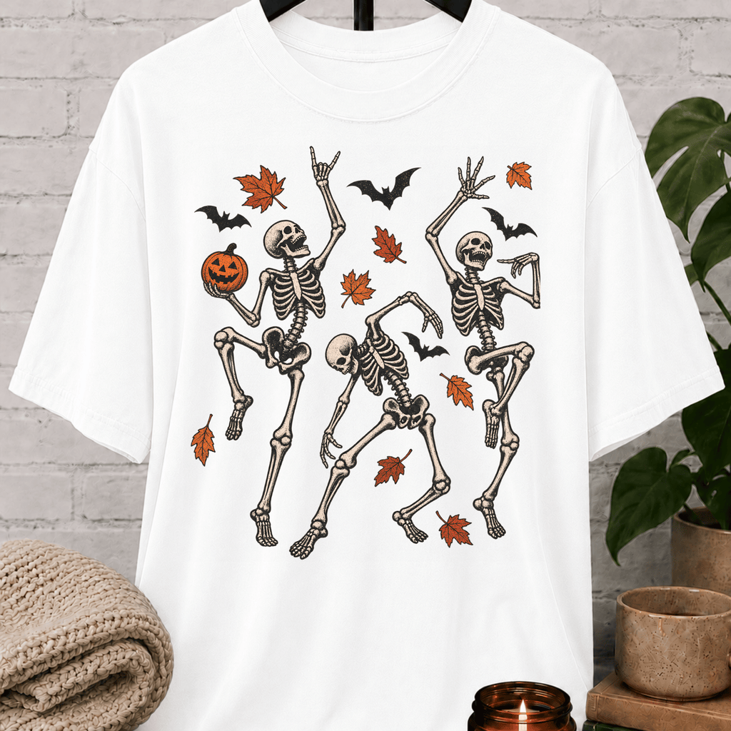 Fall Halloween skeleton T-shirt featuring three dancing skeletons, autumn leaves, bats, and a jack-o’-lantern, a spooky graphic tee for introverts and Halloween lovers.