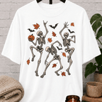 Fall Halloween skeleton T-shirt featuring three dancing skeletons, autumn leaves, bats, and a jack-o’-lantern, a spooky graphic tee for introverts and Halloween lovers.