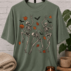 Fall Halloween skeleton T-shirt featuring three dancing skeletons, autumn leaves, bats, and a jack-o’-lantern, a spooky graphic tee for introverts and Halloween lovers.