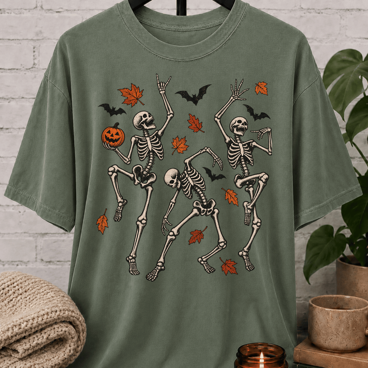 Fall Halloween skeleton T-shirt featuring three dancing skeletons, autumn leaves, bats, and a jack-o’-lantern, a spooky graphic tee for introverts and Halloween lovers.