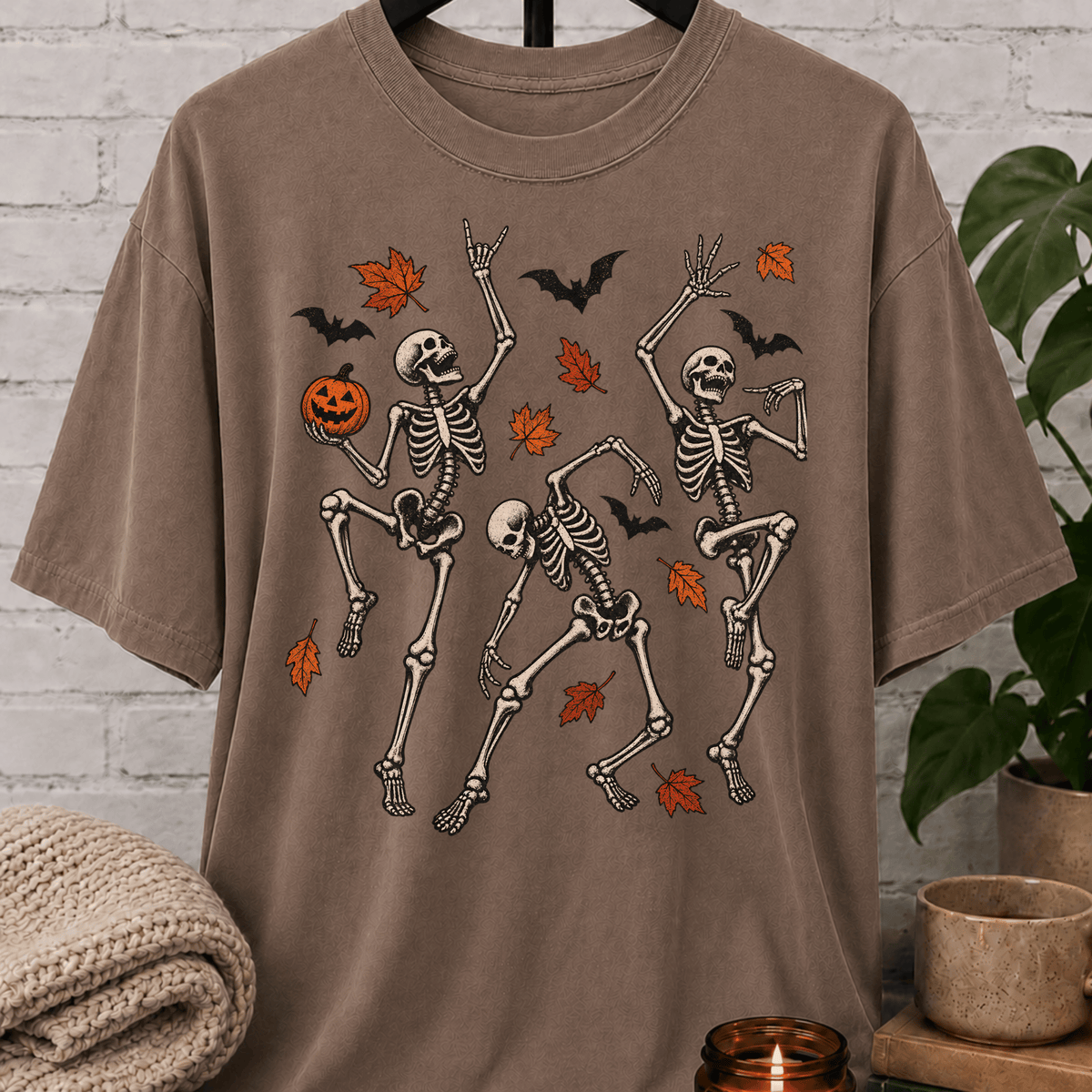 Fall Halloween skeleton T-shirt featuring three dancing skeletons, autumn leaves, bats, and a jack-o’-lantern, a spooky graphic tee for introverts and Halloween lovers.