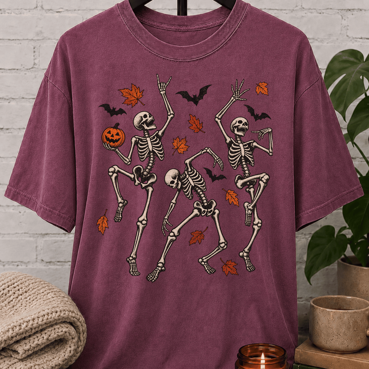 Fall Halloween skeleton T-shirt featuring three dancing skeletons, autumn leaves, bats, and a jack-o’-lantern, a spooky graphic tee for introverts and Halloween lovers.