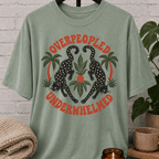 Antisocial leopard T-shirt featuring two black leopards, palm trees, tropical leaves, and the phrase “Overpeopled Underwhelmed,” a funny graphic tee for loners, socially drained people, and sarcastic people-avoidance humor fans.