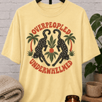 Antisocial leopard T-shirt featuring two black leopards, palm trees, tropical leaves, and the phrase “Overpeopled Underwhelmed,” a funny graphic tee for loners, socially drained people, and sarcastic people-avoidance humor fans.