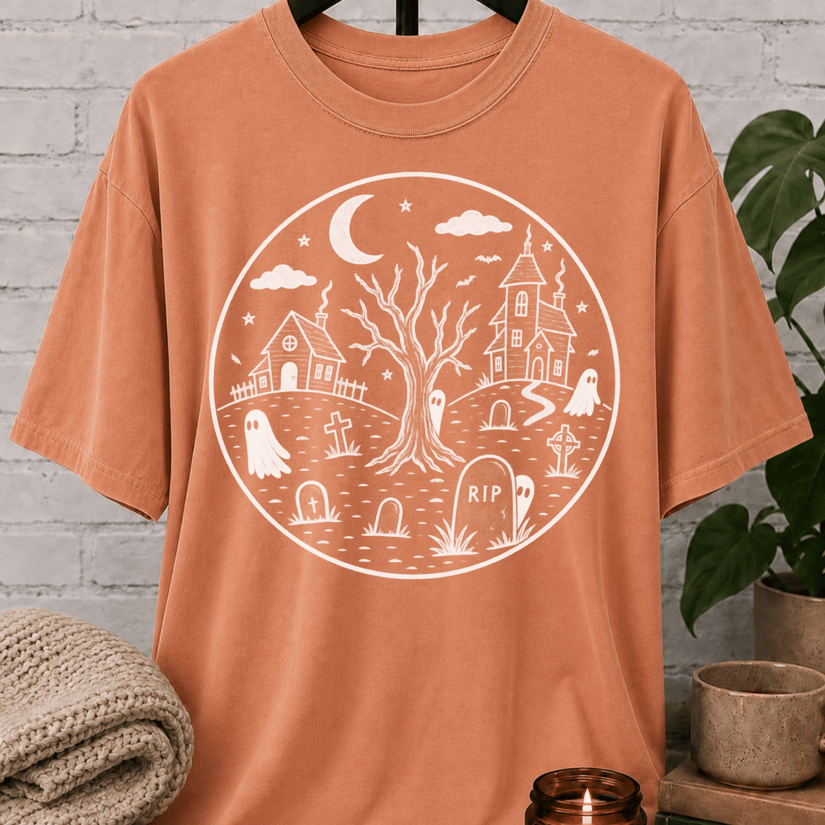 Antisocial Halloween ghost graveyard T-shirt featuring a spooky black and white haunted village scene with ghosts, tombstones, a crescent moon, bare tree, and eerie houses, a graphic tee for antisocial humor and Halloween lovers.