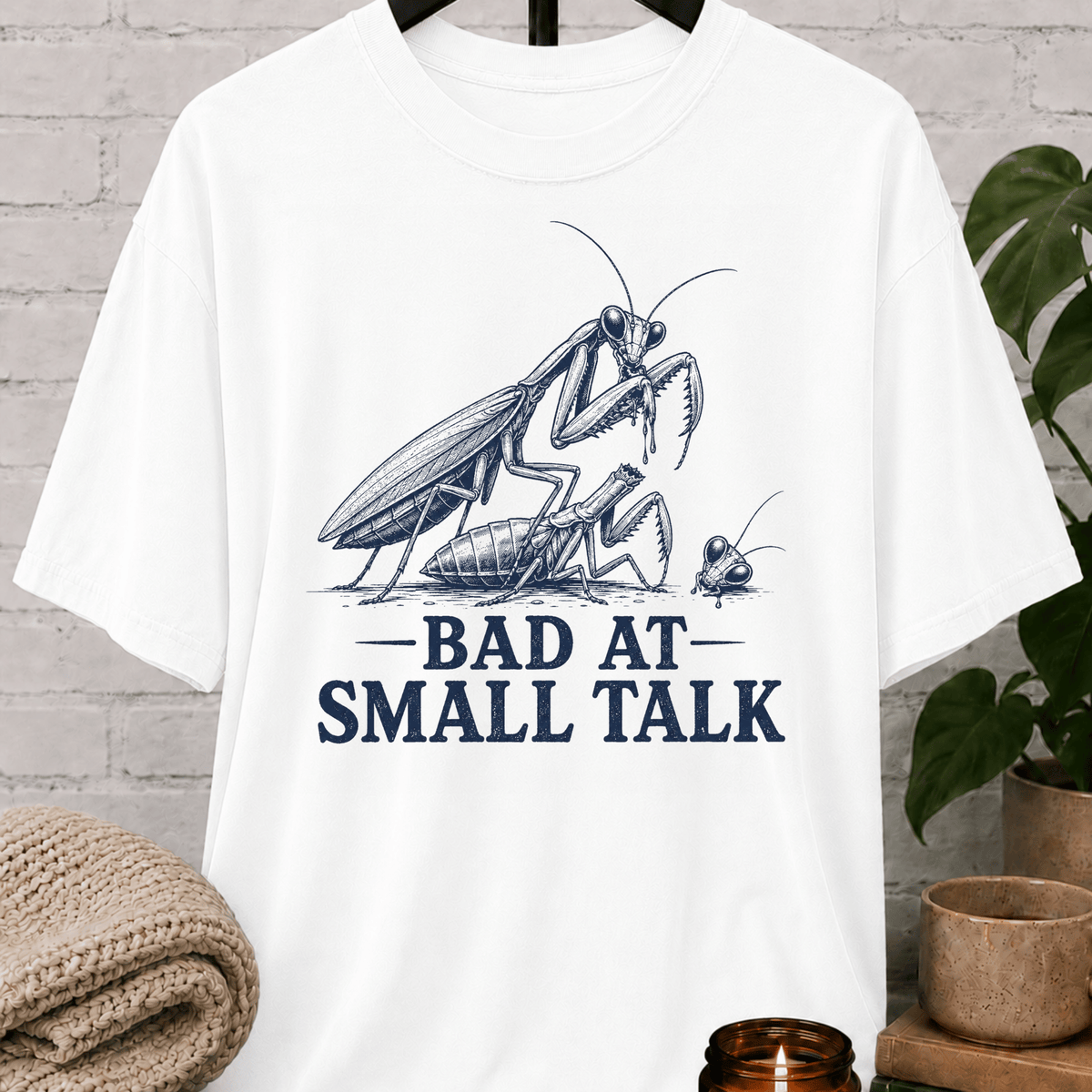 Socially awkward praying mantis T-shirt featuring two illustrated insects and the phrase “Bad at Small Talk,” a sarcastic graphic tee for awkward humor fans, quiet types, and people who hate forced conversation.