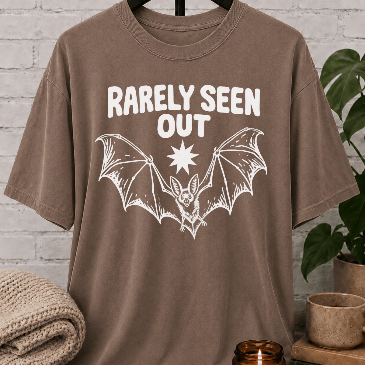Hermit bat graphic T-shirt featuring a vintage flying bat and the phrase “Barely Seen Out,” an indoorsy graphic tee for reclusive types, loners, and people who prefer staying out of sight.