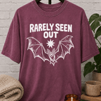 Hermit bat graphic T-shirt featuring a vintage flying bat and the phrase “Barely Seen Out,” an indoorsy graphic tee for reclusive types, loners, and people who prefer staying out of sight.