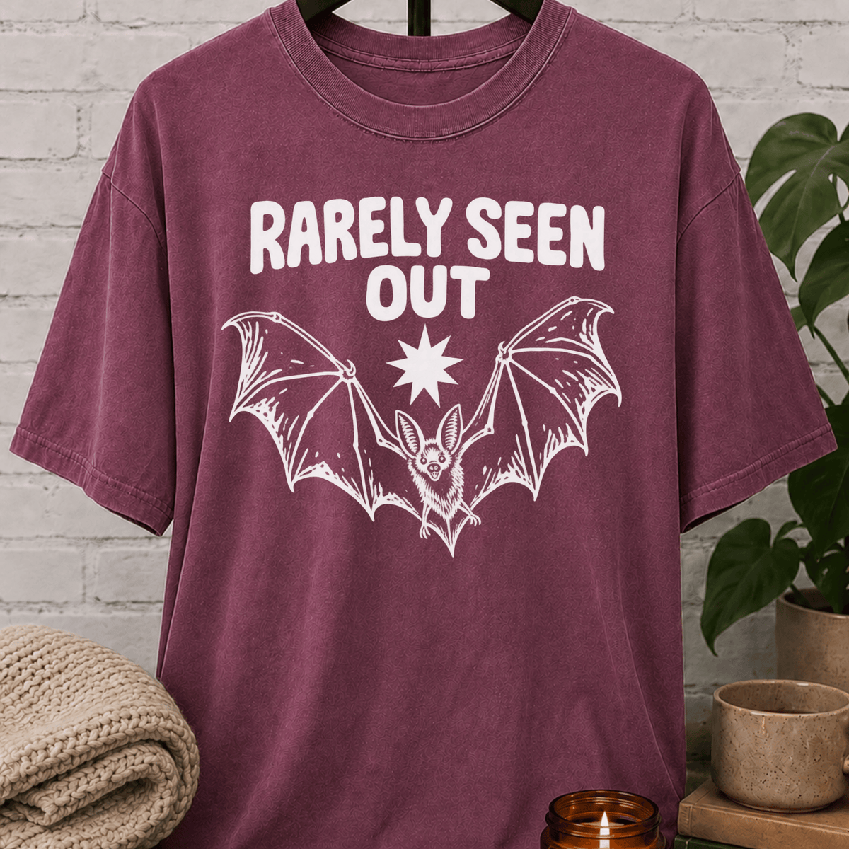 Hermit bat graphic T-shirt featuring a vintage flying bat and the phrase “Barely Seen Out,” an indoorsy graphic tee for reclusive types, loners, and people who prefer staying out of sight.