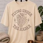 Loner eagle graphic T-shirt featuring a vintage flying eagle, lightning bolt accents, and the phrase “Flying Under the Radar,” a low-profile shirt for private people and fans of sarcastic solitude humor.