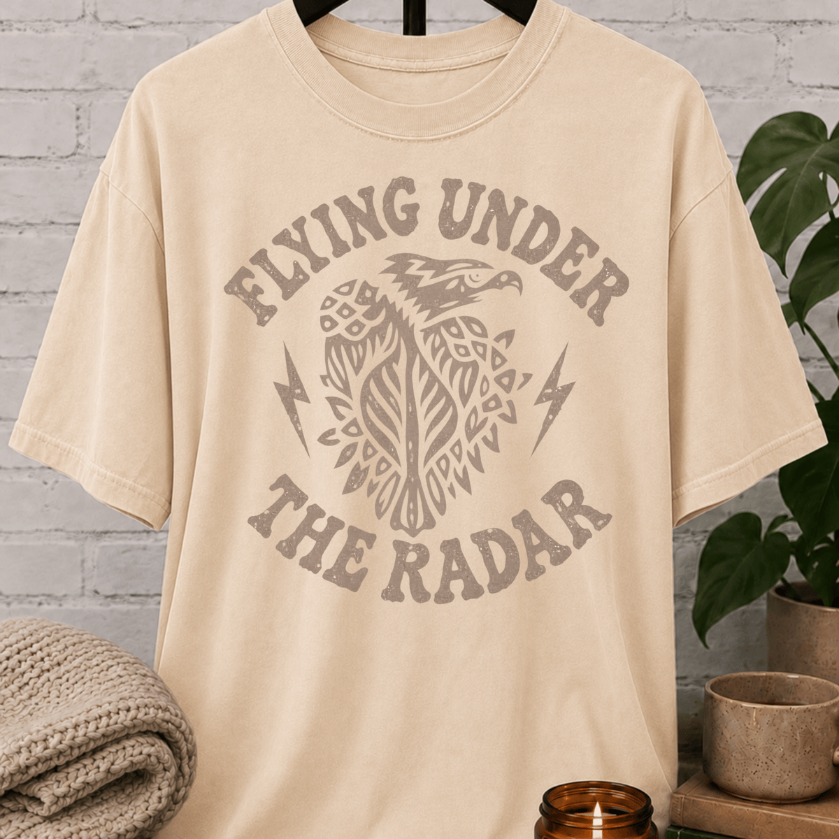 Loner eagle graphic T-shirt featuring a vintage flying eagle, lightning bolt accents, and the phrase “Flying Under the Radar,” a low-profile shirt for private people and fans of sarcastic solitude humor.