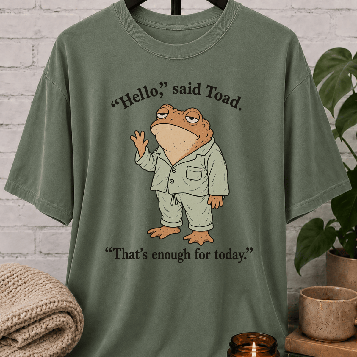 Social battery toad T-shirt featuring an unimpressed cartoon toad waving with the phrase “Hello, said Toad. That’s enough for today,” a socially drained graphic tee for awkward humor fans and people with limited social energy.