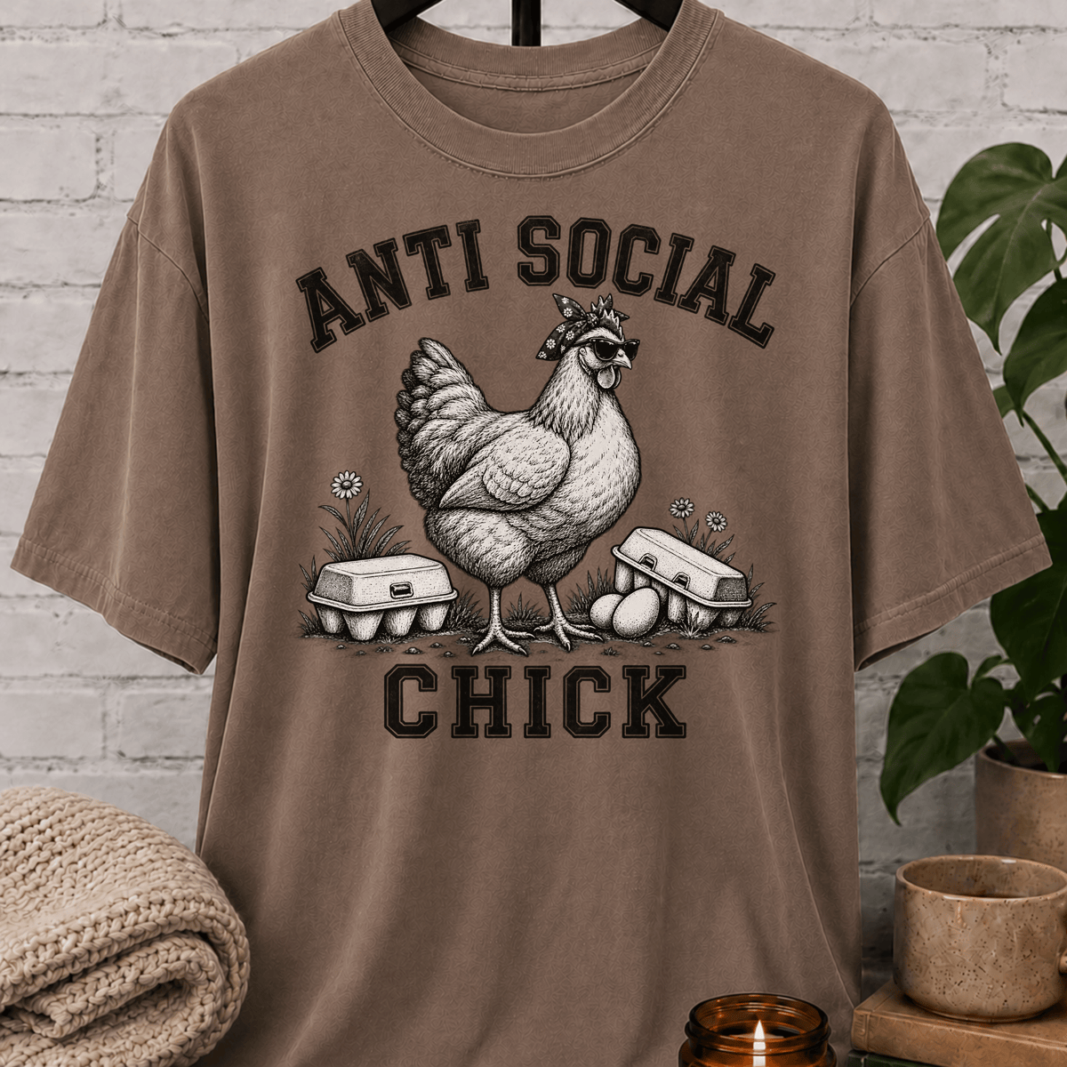 Antisocial chicken graphic T-shirt featuring a hen in sunglasses and a bandana with eggs and the phrase “Anti Social Chick,” a sarcastic farm animal shirt for socially selective humor fans.