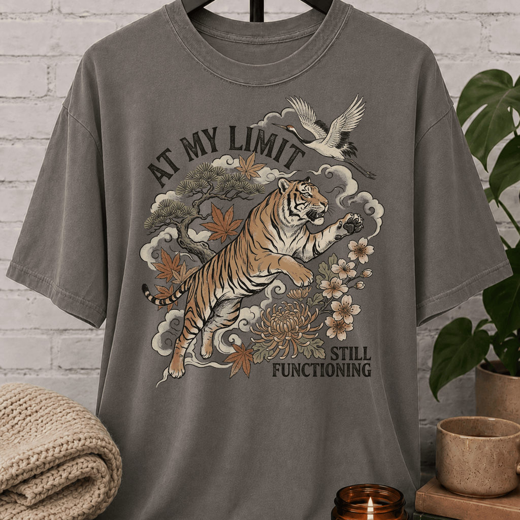 Overstimulated tiger graphic T-shirt featuring a leaping tiger with floral artwork, cranes, and the phrase “At My Limit Still Functioning,” a sarcastic graphic tee for overthinkers, overwhelmed people, and anxious humor fans.