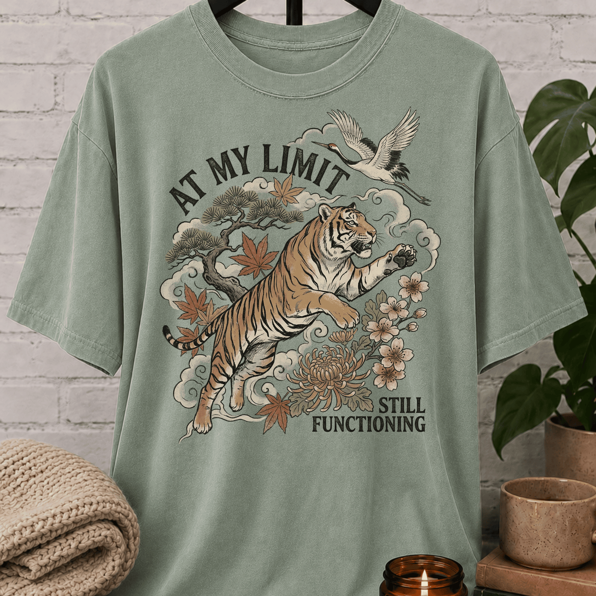 Overstimulated tiger graphic T-shirt featuring a leaping tiger with floral artwork, cranes, and the phrase “At My Limit Still Functioning,” a sarcastic graphic tee for overthinkers, overwhelmed people, and anxious humor fans.