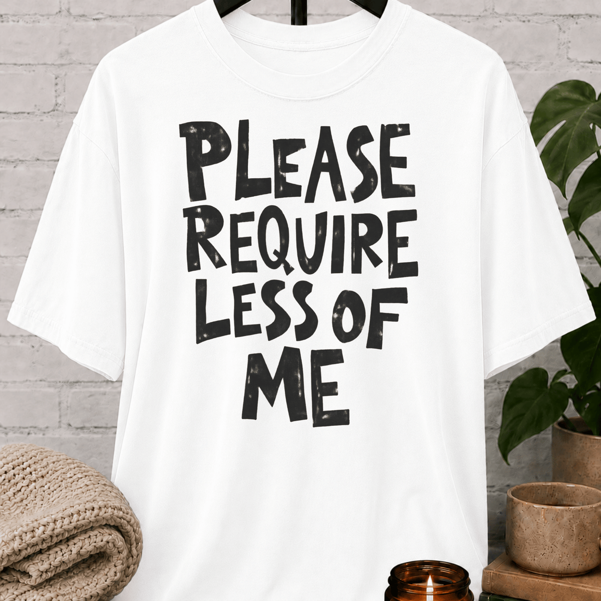 Overwhelmed humor graphic T-shirt featuring the bold phrase “Please Require Less of Me,” a sarcastic low social battery shirt for overthinkers, socially drained people, and anyone with limited bandwidth.