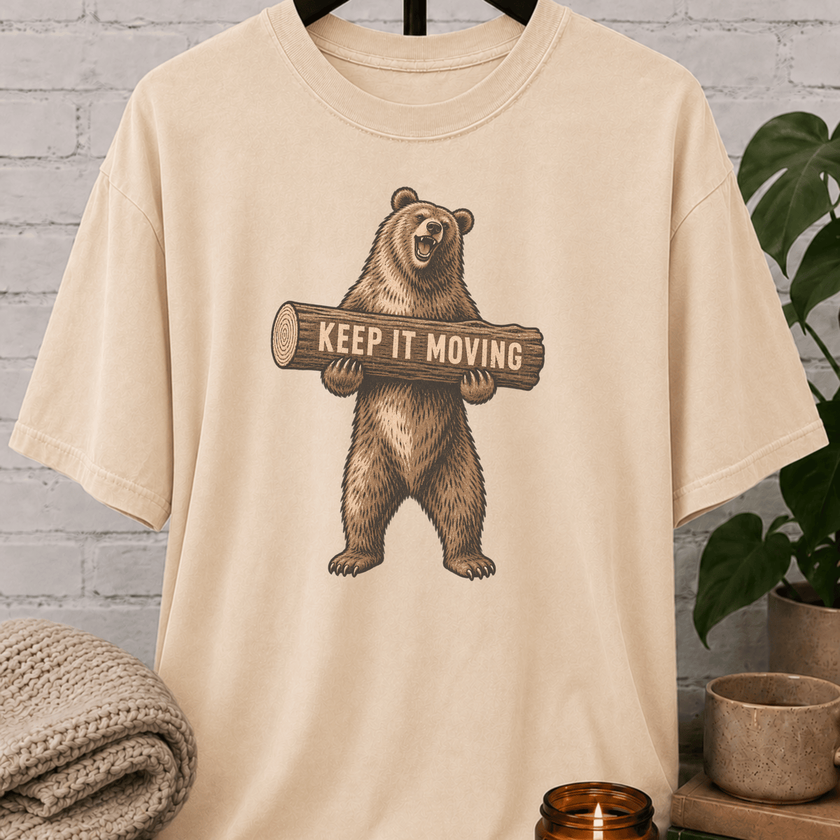 Antisocial bear graphic T-shirt featuring a standing brown bear holding a log with the phrase “Keep It Moving,” a sarcastic personal space shirt for loners, people avoiders, and fans of leave-me-alone humor.