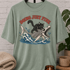 Overthinker black cat graphic T-shirt featuring a black cat riding a fish skeleton through ocean waves with the phrase “Doing Just Fine,” a sarcastic dark humor shirt for overwhelmed people and anxious humor fans.