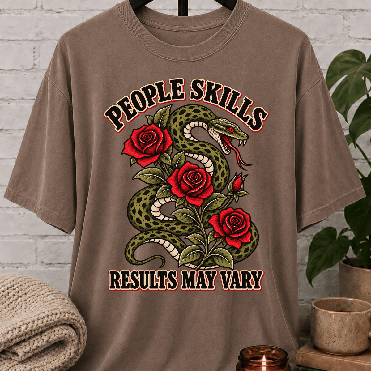 Socially awkward snake graphic T-shirt featuring a coiled green snake, red roses, and the phrase “People Skills Results May Vary,” a sarcastic graphic tee for awkward humor fans and socially selective personalities.