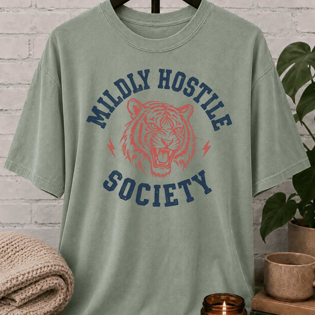 Socially selective tiger graphic T-shirt featuring a snarling tiger, lightning bolt accents, and the phrase “Mildly Hostile Society,” a sarcastic antisocial shirt for people who prefer fewer conversations and more personal space.