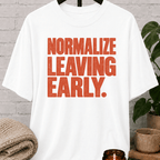 Socially selective graphic T-shirt featuring bold distressed lettering that reads “Normalize Leaving Early,” a sarcastic leave-early shirt for low social battery days and people who prefer an early exit.