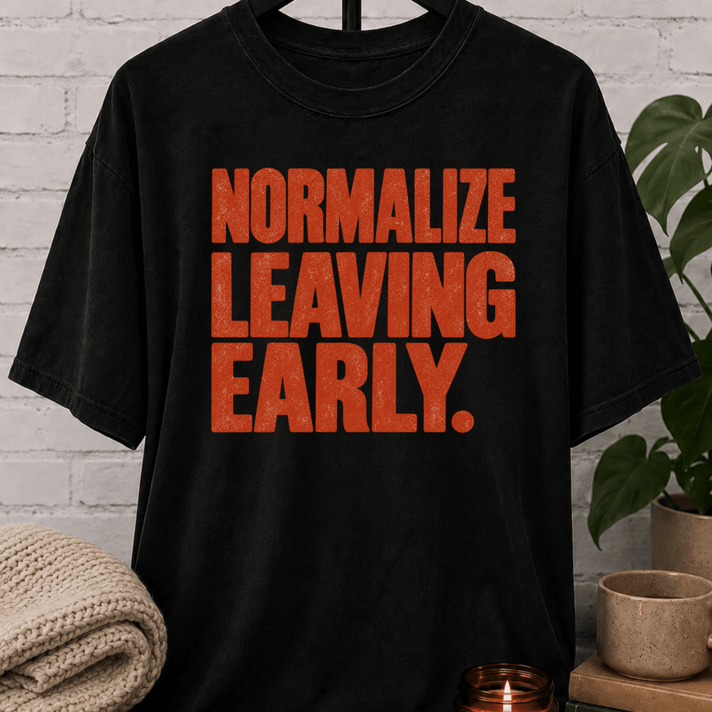 Socially selective graphic T-shirt featuring bold distressed lettering that reads “Normalize Leaving Early,” a sarcastic leave-early shirt for low social battery days and people who prefer an early exit.