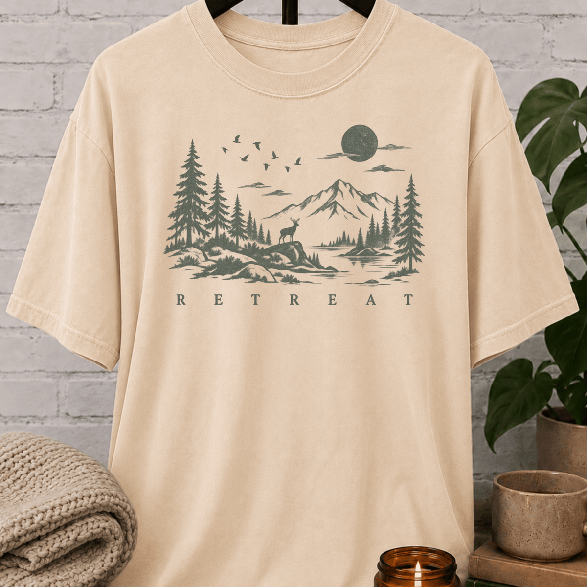 Quiet life nature graphic T-shirt featuring a mountain lake, pine trees, deer, birds, and moon with the word “Retreat,” an outdoorsy solitude shirt for people who recharge alone.