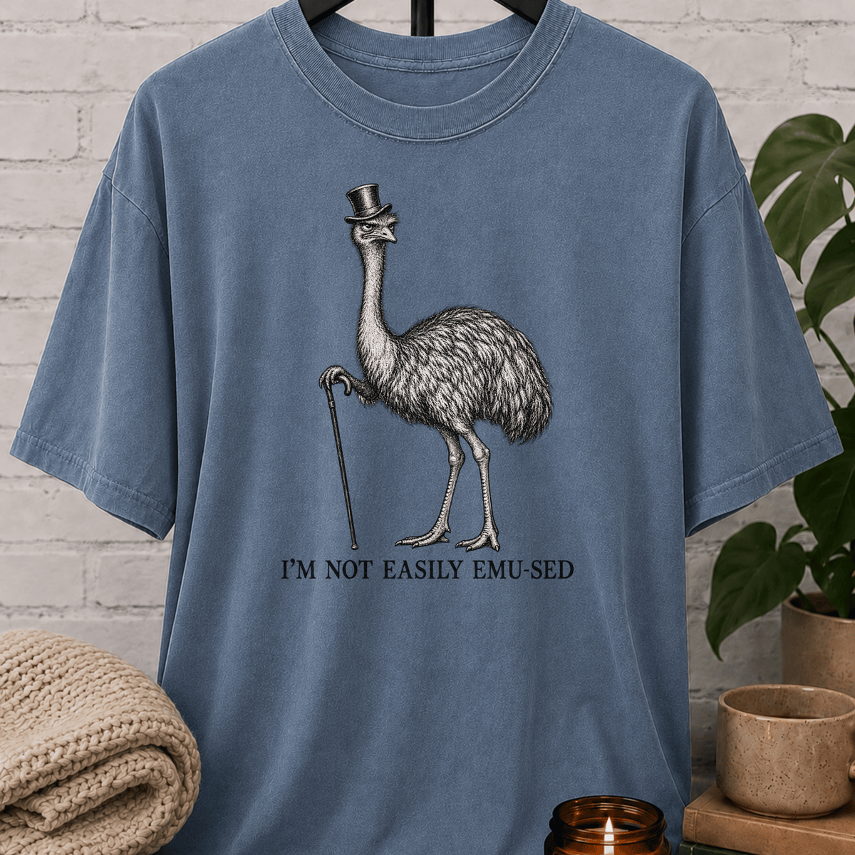 Sarcastic emu graphic T-shirt featuring a vintage emu wearing a top hat and holding a cane with the phrase “I’m Not Easily Emu-sed,” a quirky animal humor shirt for socially selective and hard-to-impress people.
