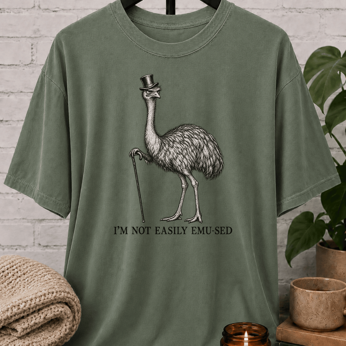 Sarcastic emu graphic T-shirt featuring a vintage emu wearing a top hat and holding a cane with the phrase “I’m Not Easily Emu-sed,” a quirky animal humor shirt for socially selective and hard-to-impress people.