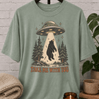UFO bear graphic T-shirt featuring a black bear being abducted by a flying saucer above a pine forest with the phrase “Take Me With You,” an alien abduction shirt for loners, solitude lovers, and people-avoidance humor fans.