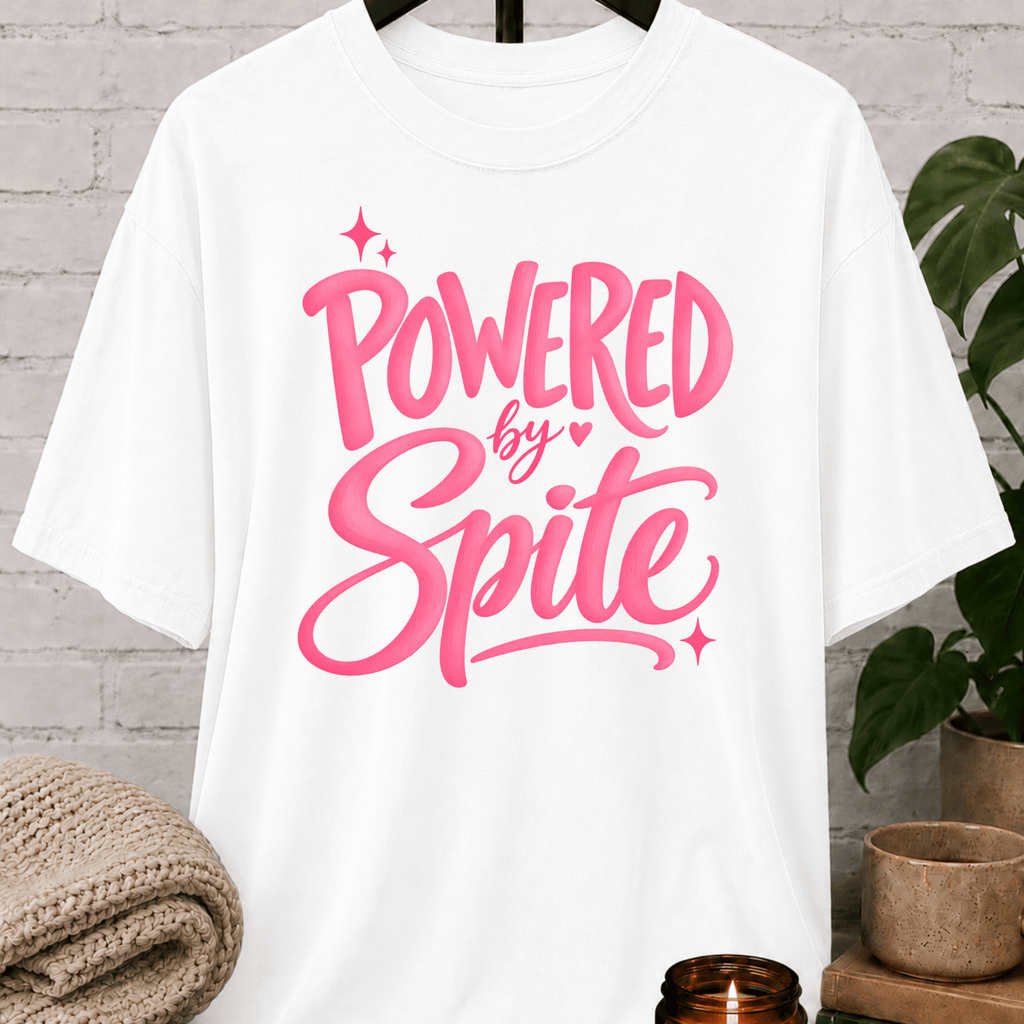 Powered by Spite graphic T-shirt featuring bold lettering and sparkle accents, a sarcastic petty humor shirt for stubborn personalities, spiteful humor fans, and people fueled by determination.