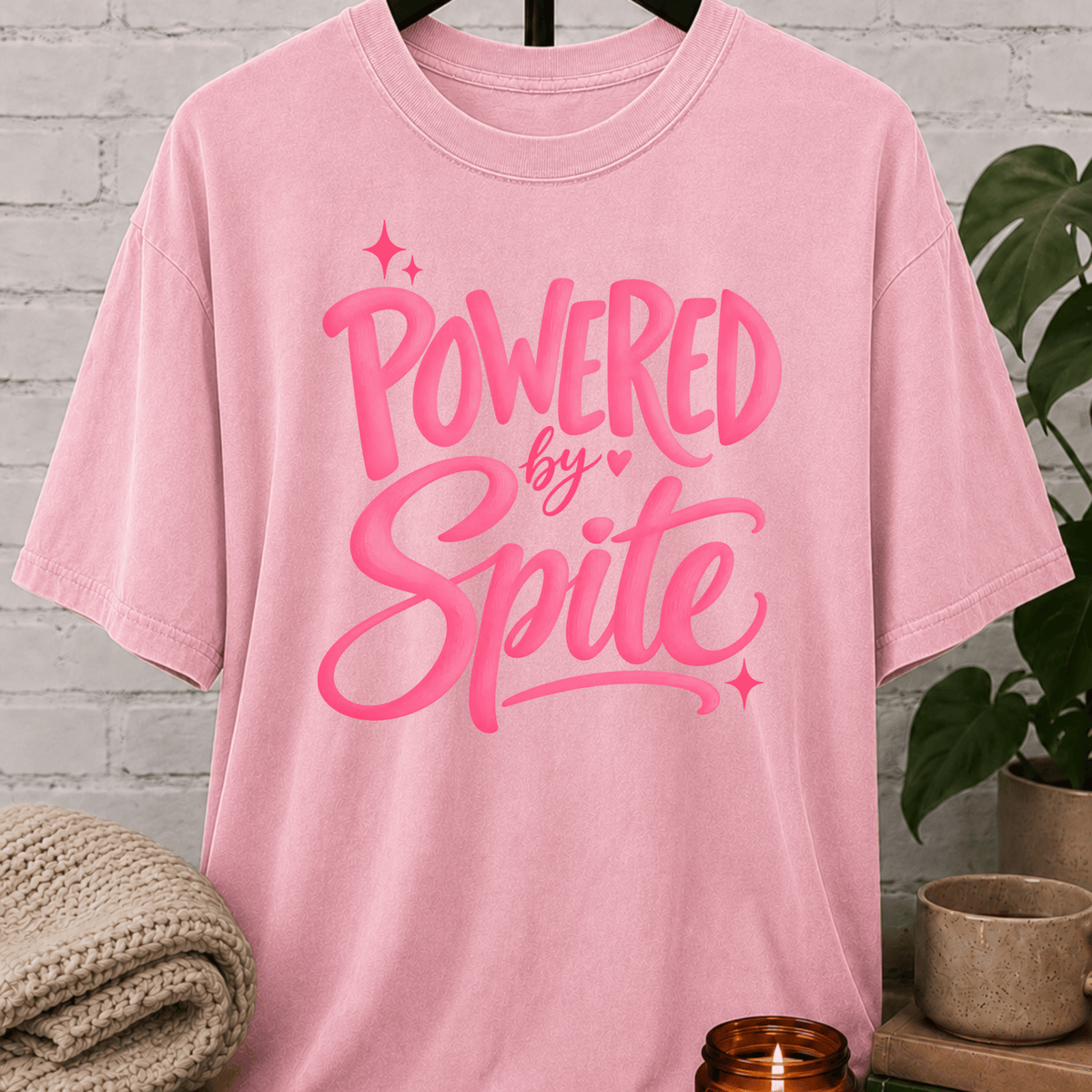 Powered by Spite graphic T-shirt featuring bold lettering and sparkle accents, a sarcastic petty humor shirt for stubborn personalities, spiteful humor fans, and people fueled by determination.