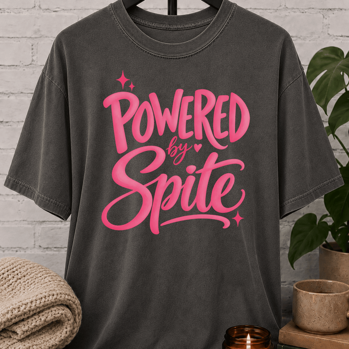 Powered by Spite graphic T-shirt featuring bold lettering and sparkle accents, a sarcastic petty humor shirt for stubborn personalities, spiteful humor fans, and people fueled by determination.