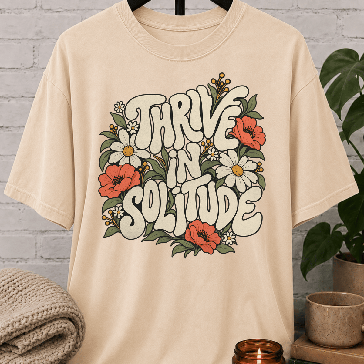 Solitude floral graphic T-shirt featuring retro daisies, poppies, leafy botanical artwork, and the phrase “Thrive in Solitude,” a loner shirt for people who enjoy alone time, quiet living, and their own company.