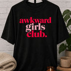 Socially awkward graphic T-shirt featuring the phrase “Awkward Girls Club” in bold retro lettering, an awkward humor shirt for women, shy personalities, and socially clumsy girls.