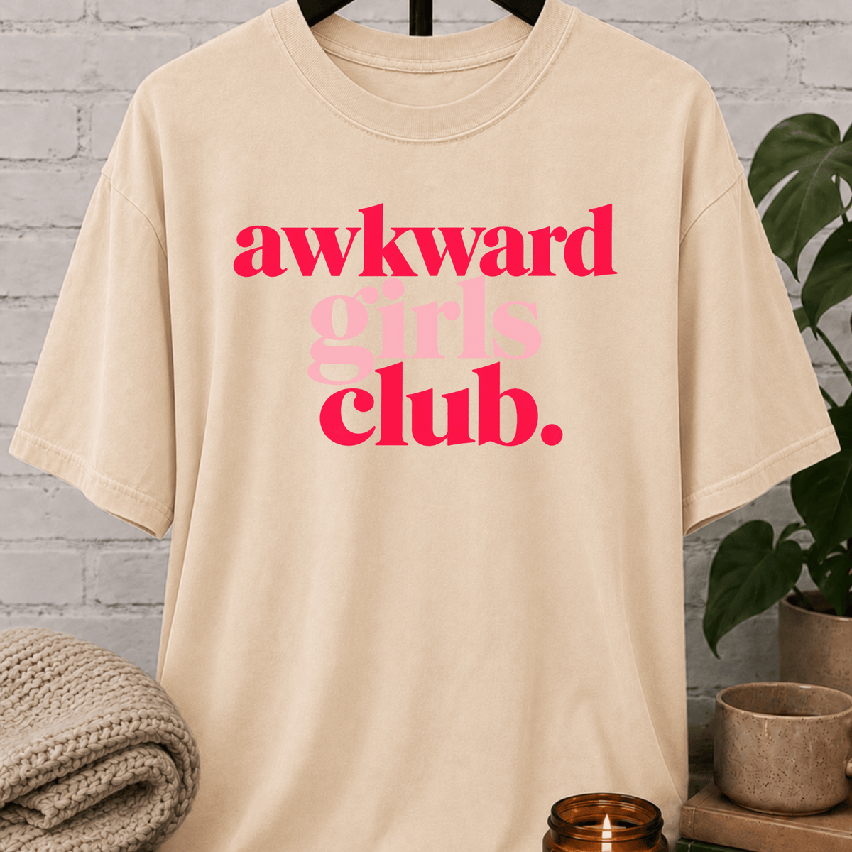 Socially awkward graphic T-shirt featuring the phrase “Awkward Girls Club” in bold retro lettering, an awkward humor shirt for women, shy personalities, and socially clumsy girls.