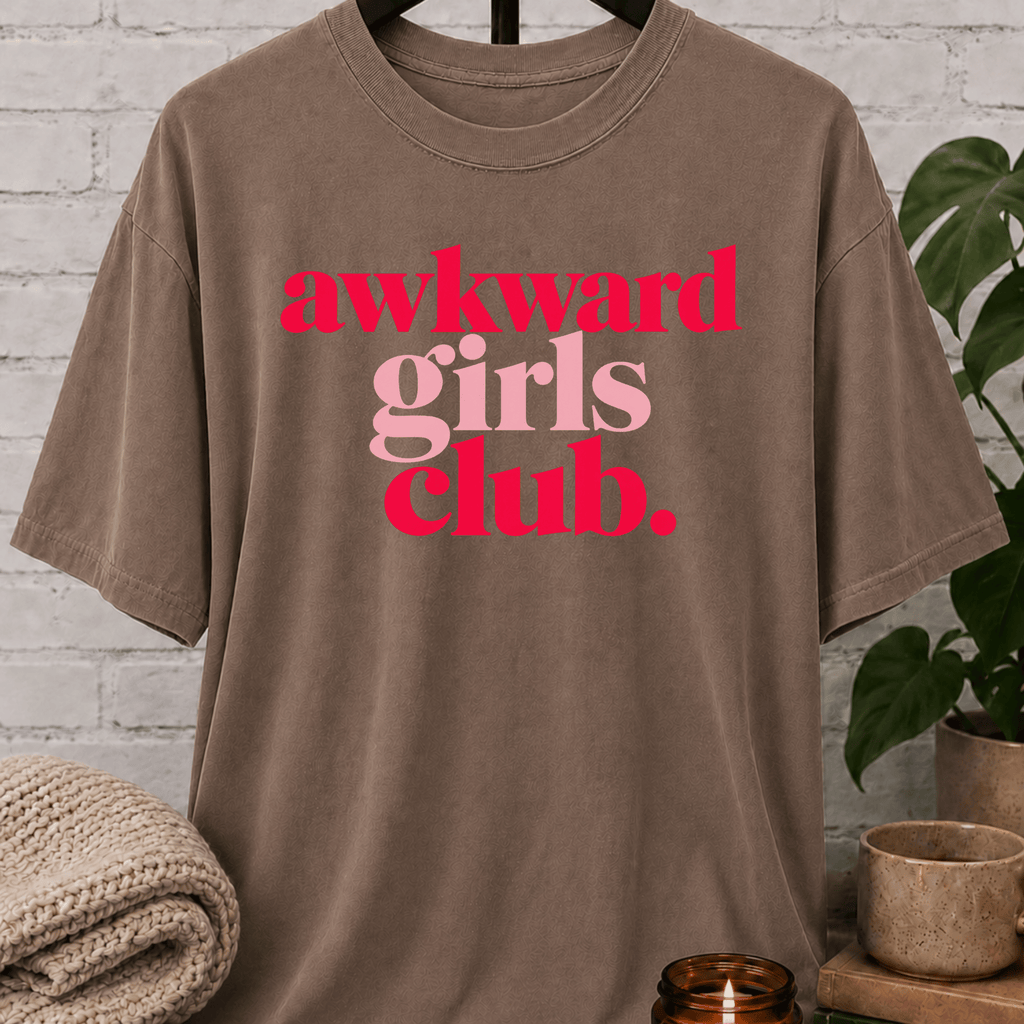 Socially awkward graphic T-shirt featuring the phrase “Awkward Girls Club” in bold retro lettering, an awkward humor shirt for women, shy personalities, and socially clumsy girls.