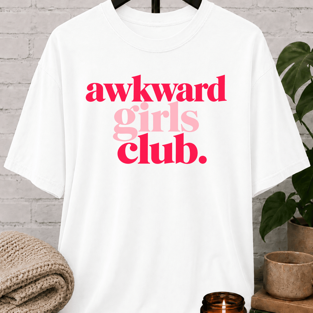 Socially awkward graphic T-shirt featuring the phrase “Awkward Girls Club” in bold retro lettering, an awkward humor shirt for women, shy personalities, and socially clumsy girls.